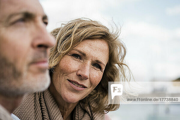 Thoughtful mature man by smiling woman