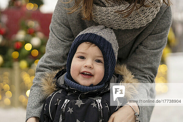 Cute boy with mother at Christmas market