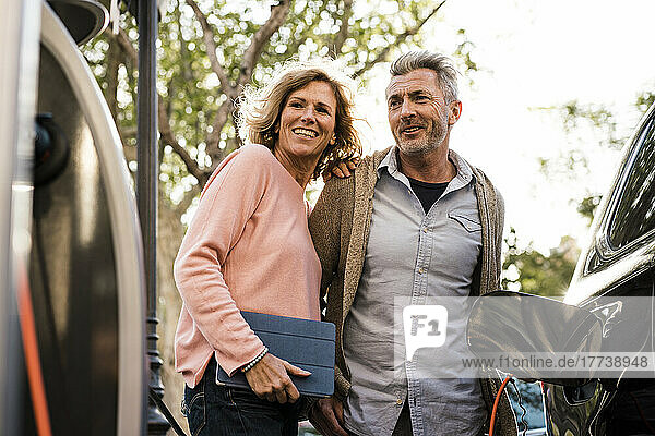 Smiling mature couple looking at charging station