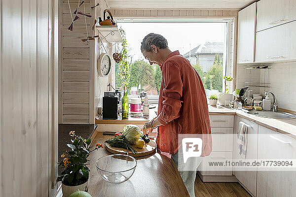 Woman with vegetables in kitchen at home