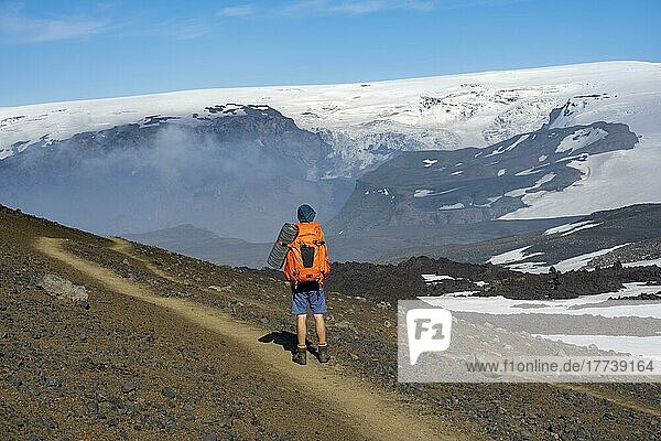 Hikers on trail through volcanic landscape  Myrdalsjökull glacier in the back  Fimmvörðuháls hiking trail  Þórsmörk Nature Reserve  Suðurland  Iceland  Europe