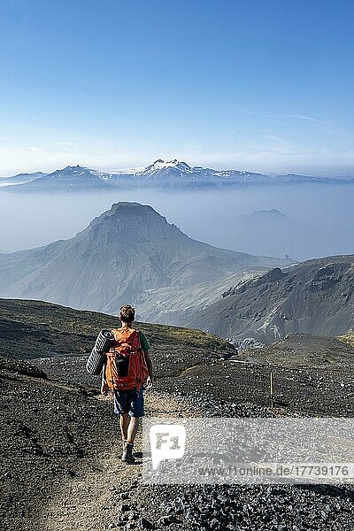 Wanderer auf Wanderweg durch vulkanische Landschaft  Ausblick auf Berge zwischen Nebel  Wanderweg Fimmvörðuháls  Þórsmörk Nature Reserve  Suðurland  Island  Europa