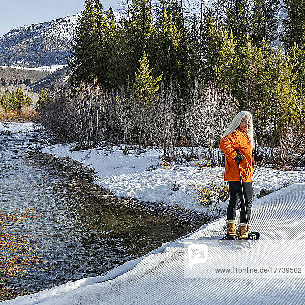 USA  Idaho  Ketchum  Senior blonde woman snowshoeing in snow covered landscape