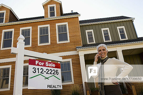 Real Estate agent in front of house