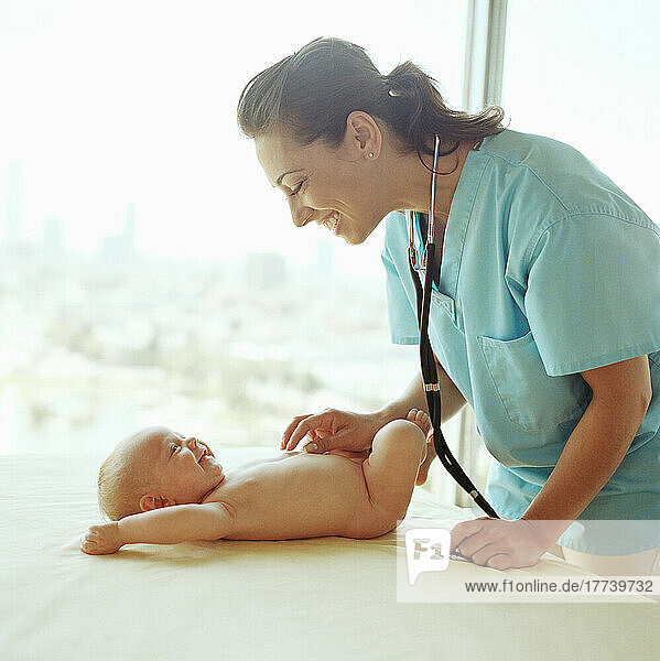 Doctor examining baby girl (2-5 months)