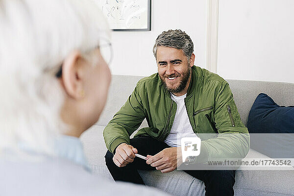 Smiling man talking with female psychotherapist in therapy office