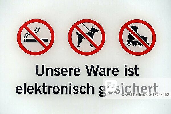 Warnschild mit drei Piktogrammen  Rauchverbot  Hundeverbot  Skaterverbot und der Aufschrift  unsere Ware ist elektronisch gesichert