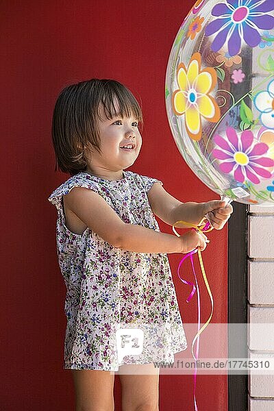Kleinkind Mädchen hält einen großen Ballon