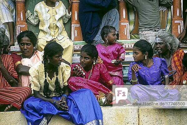 Dorfmädchen und Frauen sitzen während des Sivarathri-Festes in einem Dorf in Tamil Nadu  Indien  unter dem Fuß der Ayyanar-Statue  Asien