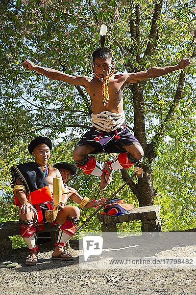Naga-Stammesangehöriger in traditioneller Kleidung  der einen Kriegertanz aufführt  Kisima Nagaland Hornbill Festival  Kohima  Nagaland  Indien  Asien
