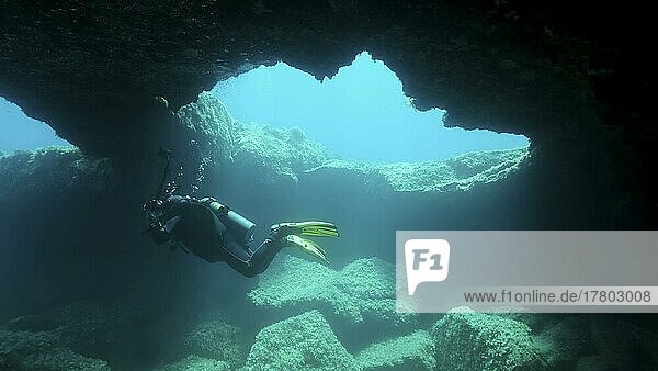 Scuba diver photographer swim in the cave. Cave diving in Mediterranean Sea  Cyprus  Europe