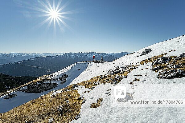 Bergsteiger neben einem Steinmännchen  vor verschneiten Bergen des Rofan  Wanderweg zum Guffert mit erstem Schnee  im Herbst  Sonnenstern  Brandenberger Alpen  Tirol  Österreich  Europa