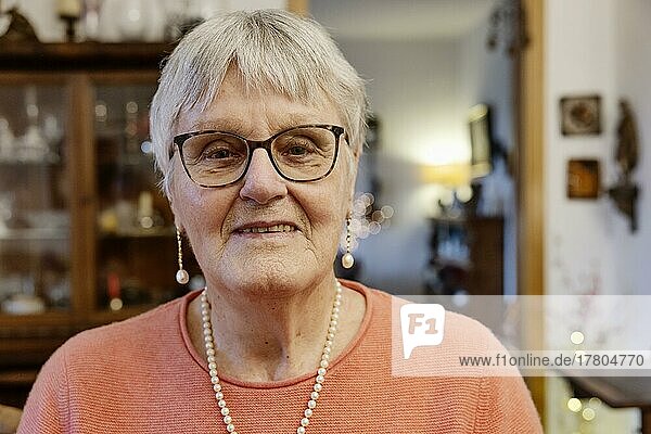 Portrait einer Seniorin mit Brille mit Blick in die Kamera zuhause  Bocholt  Nordrhein-Westfalen  Deutschland  Europa