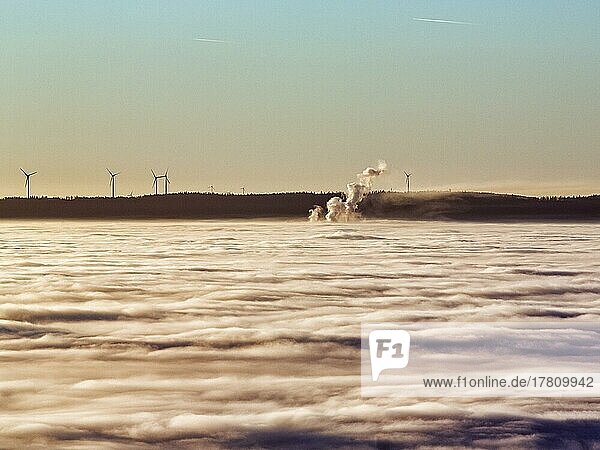 Drei Dampfsäulen ragen aus Wolkendecke  Windräder  Windkraftwerk am Horizont  Abendsonne  Köterberg  Lügde  Weserbergland  Nordrhein-Westfalen  Deutschland  Europa