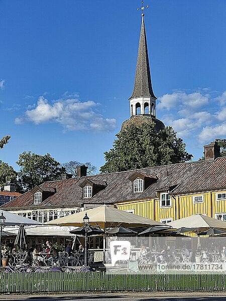 Terrasse eines Restaurants mit Touristen  Kirchturm der Dorfkirche im Sommer  Mariefred  Strängnäs  Södermanlands län  Schweden  Europa