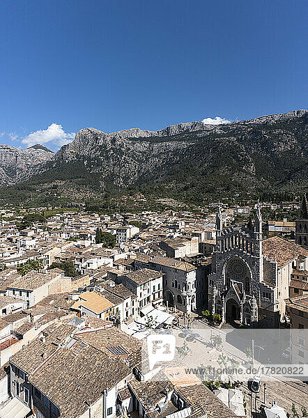 Spain  Balearic Islands  Soller  Helicopter view of Church of Saint Bartholomew and surrounding houses with Serra de Tramuntana mountains in background