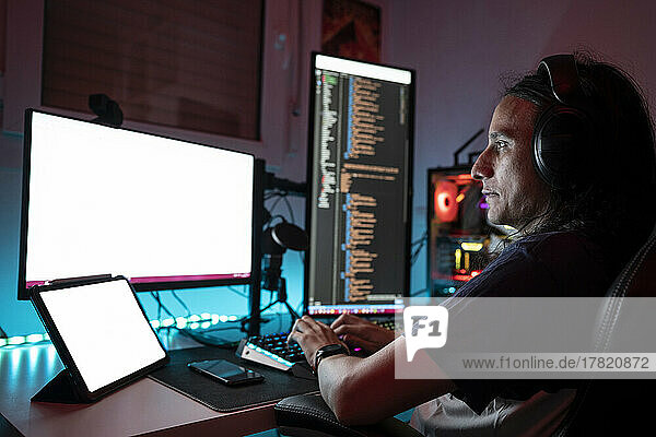 Man wearing headphones using computer at home