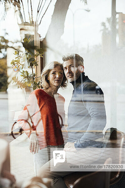 Man with woman in cafe seen through glass