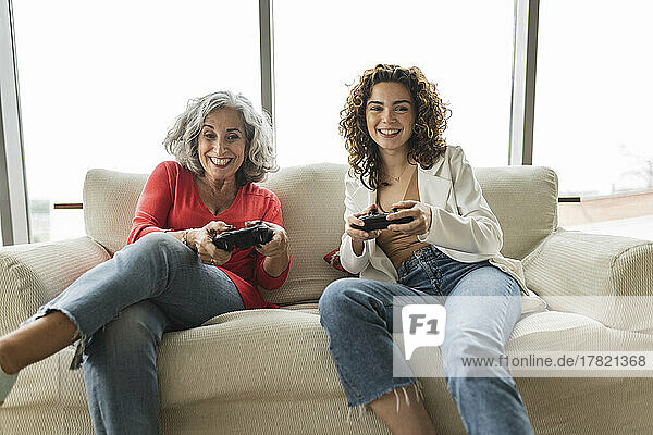 Happy woman with friend playing video games