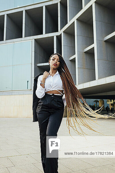 Selbstbewusste junge Geschäftsfrau mit langen braunen geflochtenen Haaren