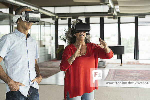 Geschäftskollegen mit Virtual-Reality-Simulator gestikulieren im Büro