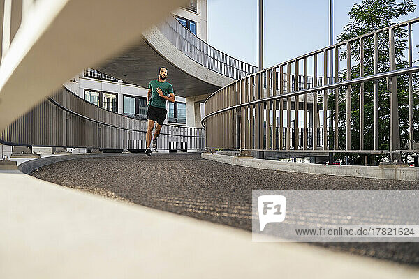Young man jogging on elevated walkway