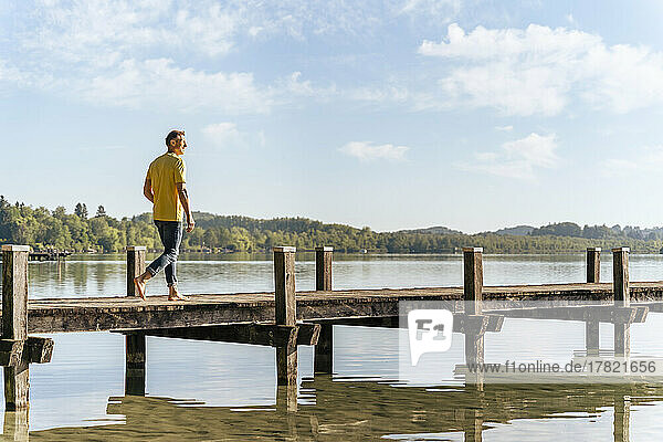 Man walking on pier at lake
