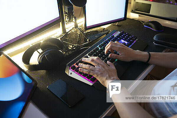 Mann tippt auf der Tastatur und sitzt vor dem Desktop-PC