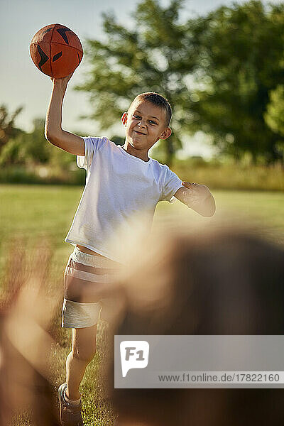 Junge wirft Schwester an sonnigem Tag Rugbyball zu