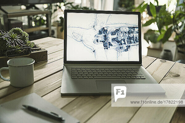 Sketch of wind turbine on laptop screen at home office