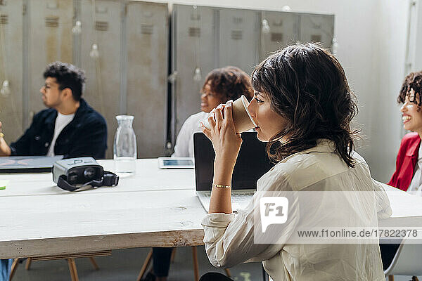 Businesswoman drinking coffee in business meeting at work place