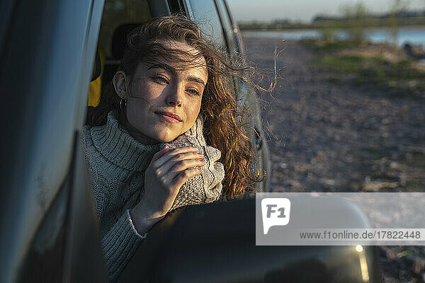 Young woman looking out through car window