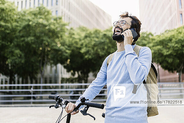 Happy bearded man talking on mobile phone