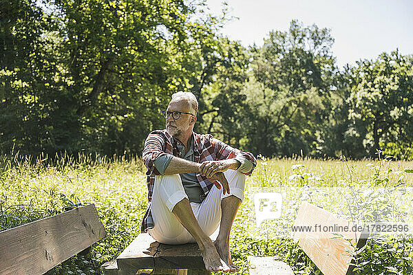 Senior man sitting on picnic table in park