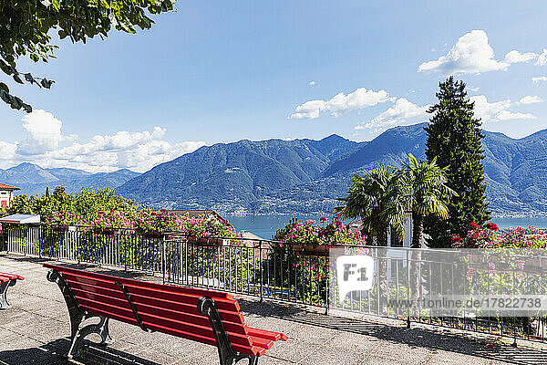 Switzerland  Ticino  Locarno  Park bench overlooking Lake Maggiore and surrounding mountains in summer