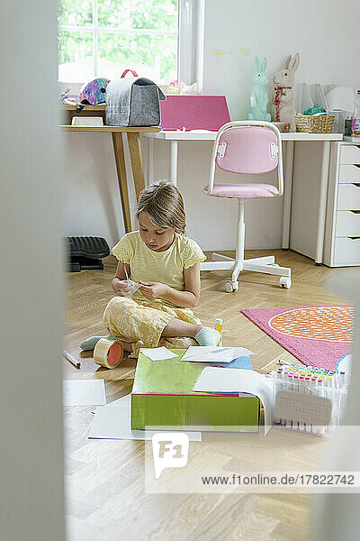 Girl doing craftwork sitting at home