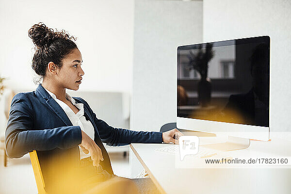 Businesswoman with desktop PC sitting at desk