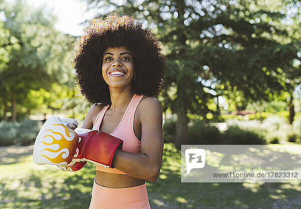 Happy woman with boxing gloves in public park