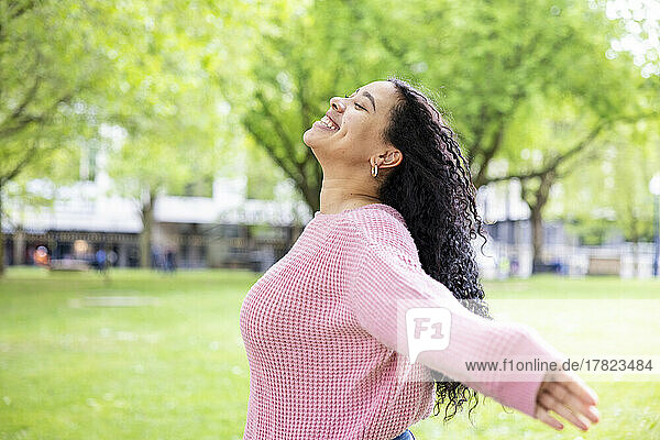 Happy woman with eyes closed enjoying at park