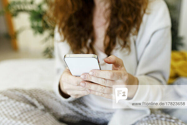 Woman using mobile phone at home