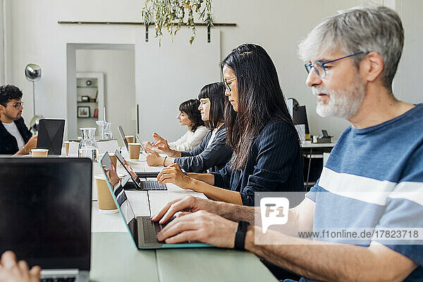 Gemischtrassige Geschäftsleute arbeiten am Laptop am Schreibtisch im Büro