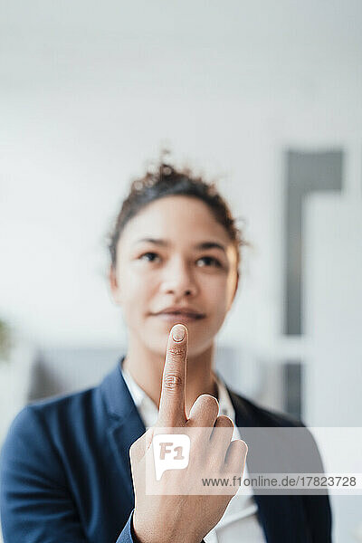 Smiling young businesswoman pointing finger