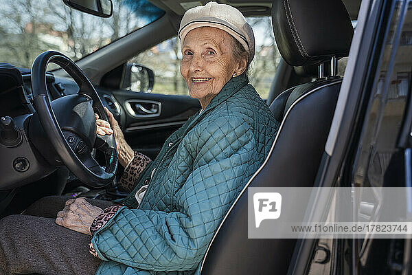 Lächelnde ältere Frau sitzt im Auto