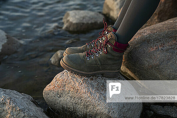 Legs of woman wearing shoes on rock