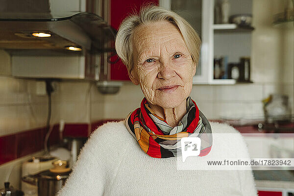 Smiling senior woman with short white hair in kitchen