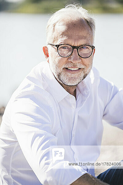 Smiling senior man wearing eyeglasses on sunny day