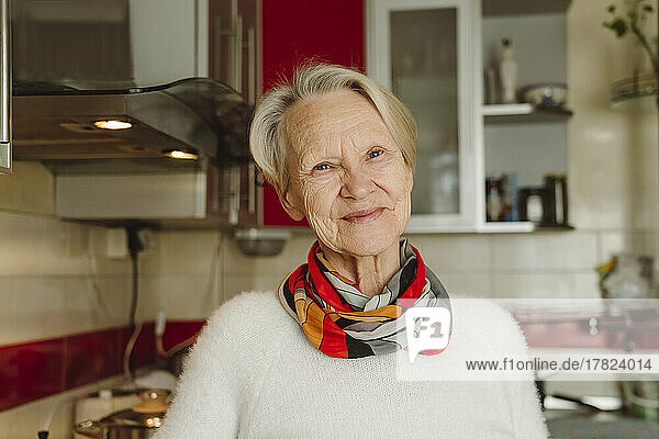 Smiling senior woman with wrinkles in kitchen