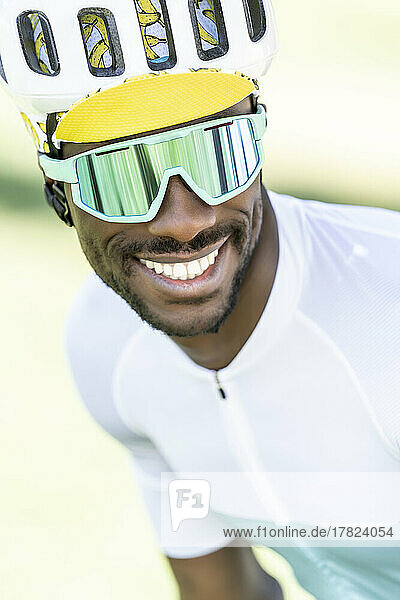 Glücklicher Radfahrer mit Fahrradhelm und Sonnenbrille
