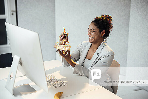 Happy businesswoman examining architectural model at office