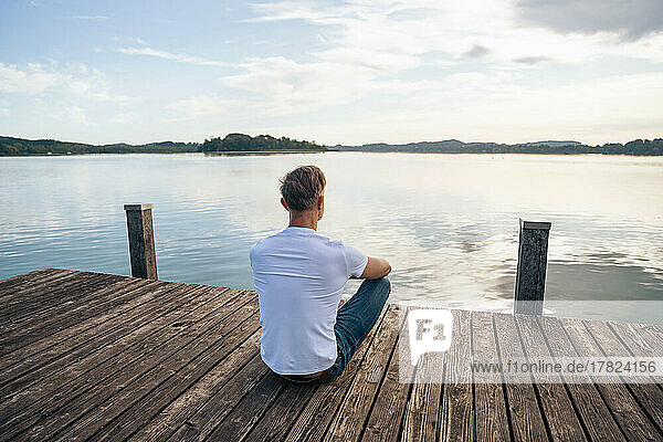 Man looking at scenic view from pier over lake